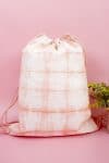 Blush pink Shibori tie-dyed drawstring backpack on pink background
