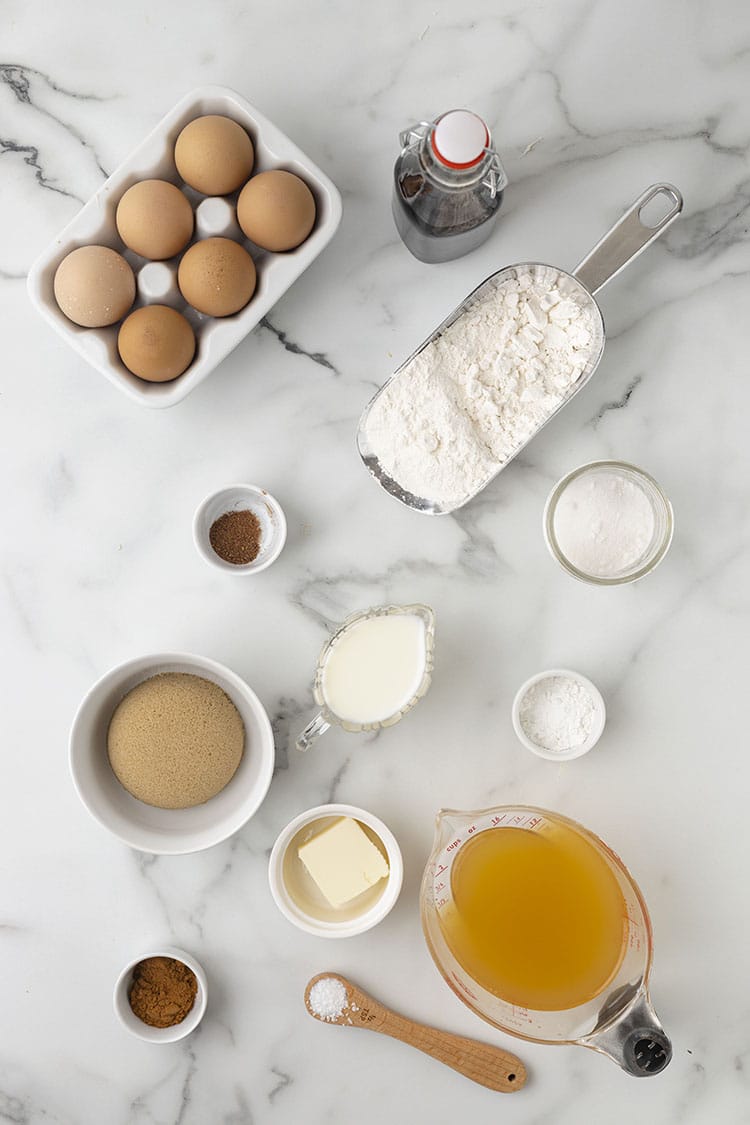 Apple cider donut ingredients on a grey and white marble background