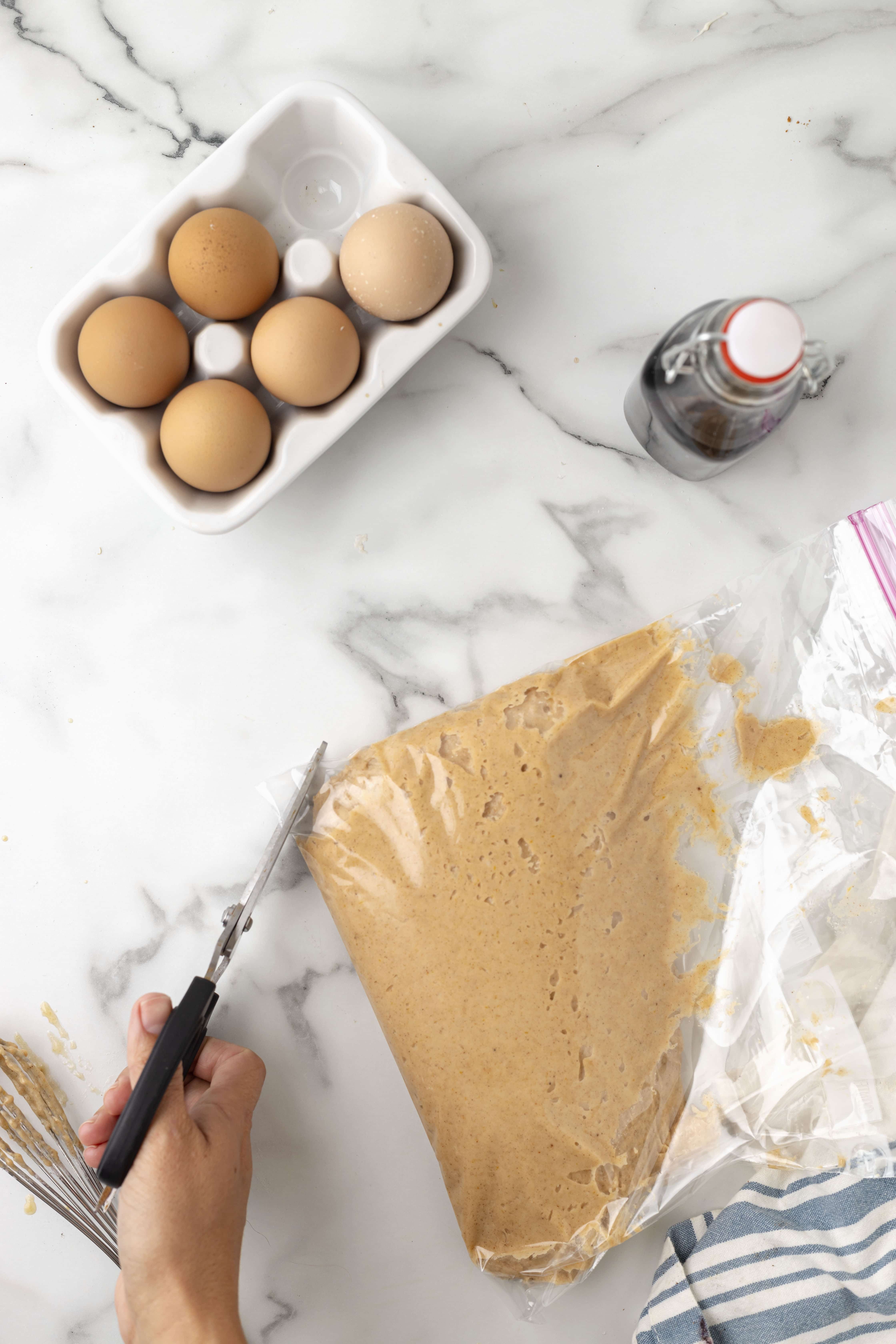 cutting hole in ziplock bag containing donut recipe ingredients