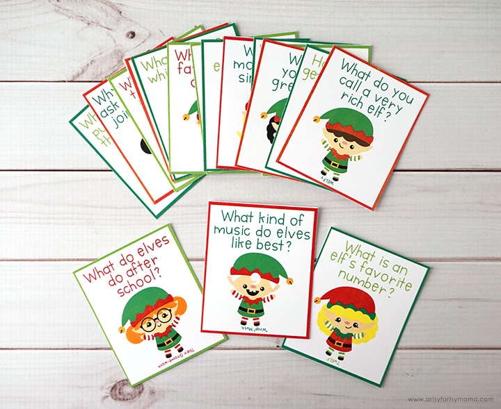 Printable elf jokes with pictures of elves on note cards on white wood background