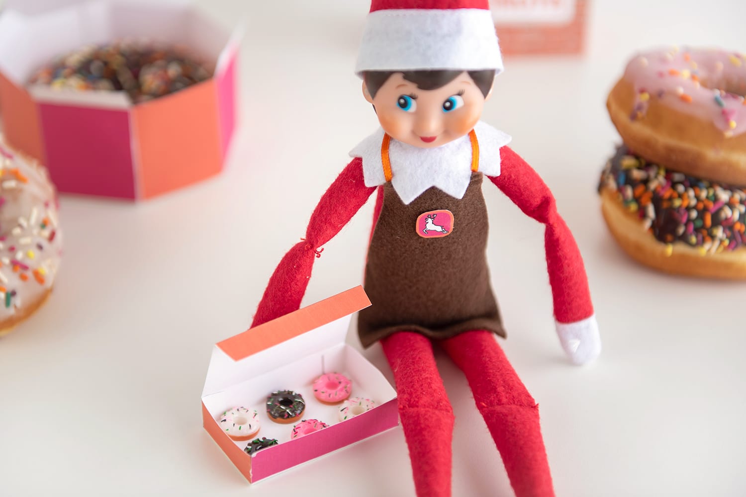 Mini donuts in a printable elf-sized donut box with Elf on the Shelf doll