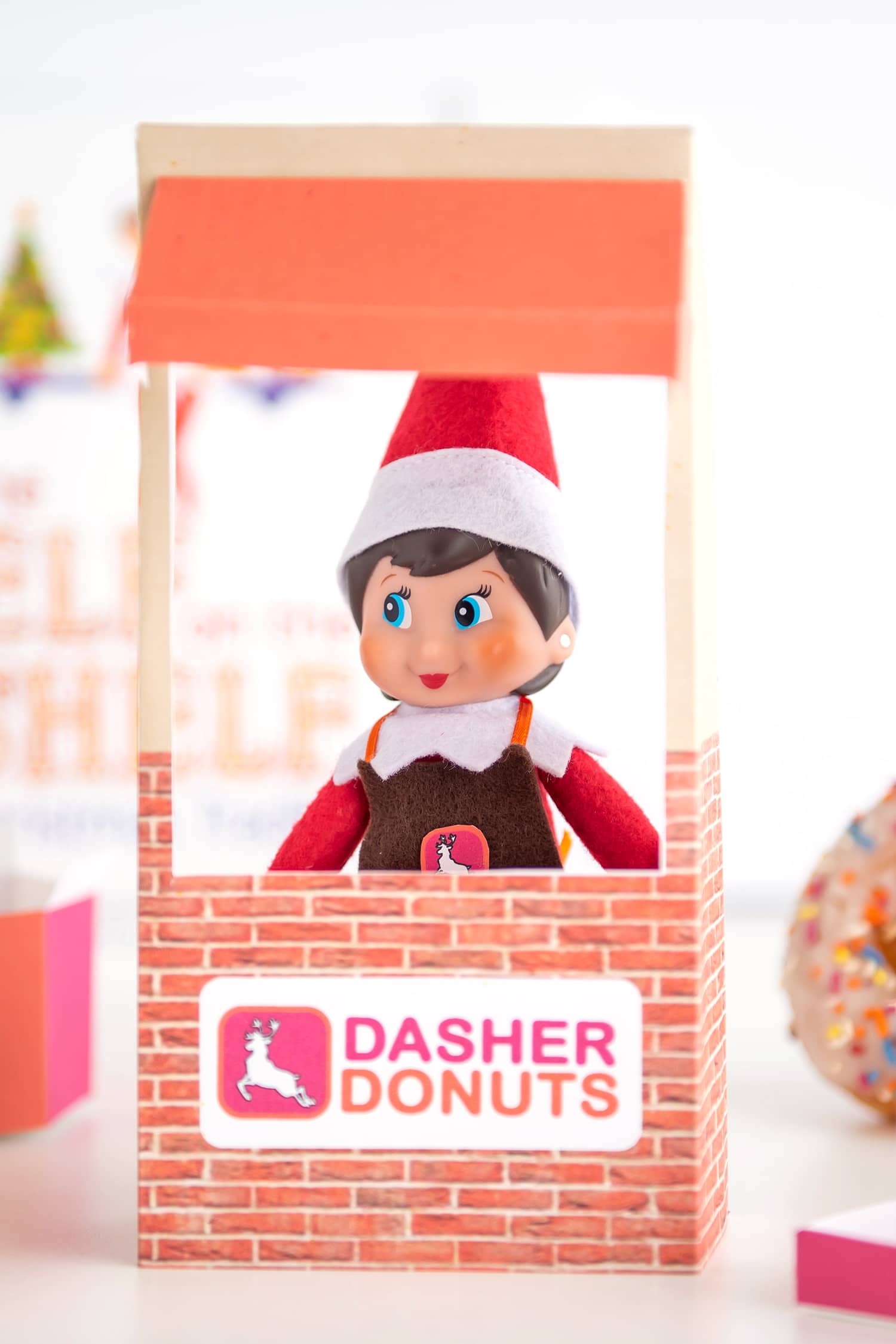 Cute Elf on the Shelf doll in a "Dasher Donuts" drive thru window