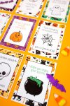 Close up of cauldron Halloween lunch note card with bat and candy corn on orange background