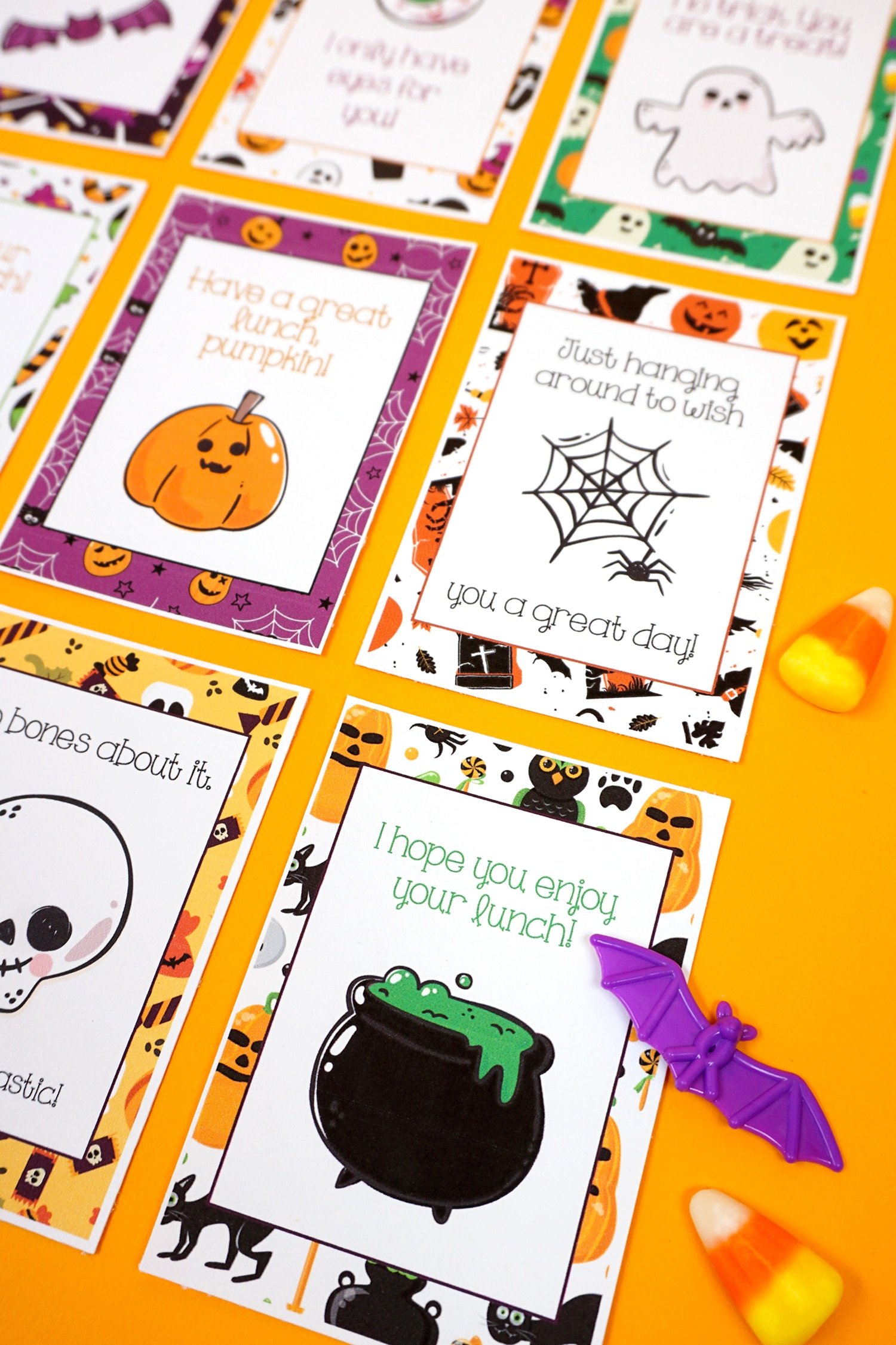 Close up of cauldron Halloween lunch note card with bat and candy corn on orange background