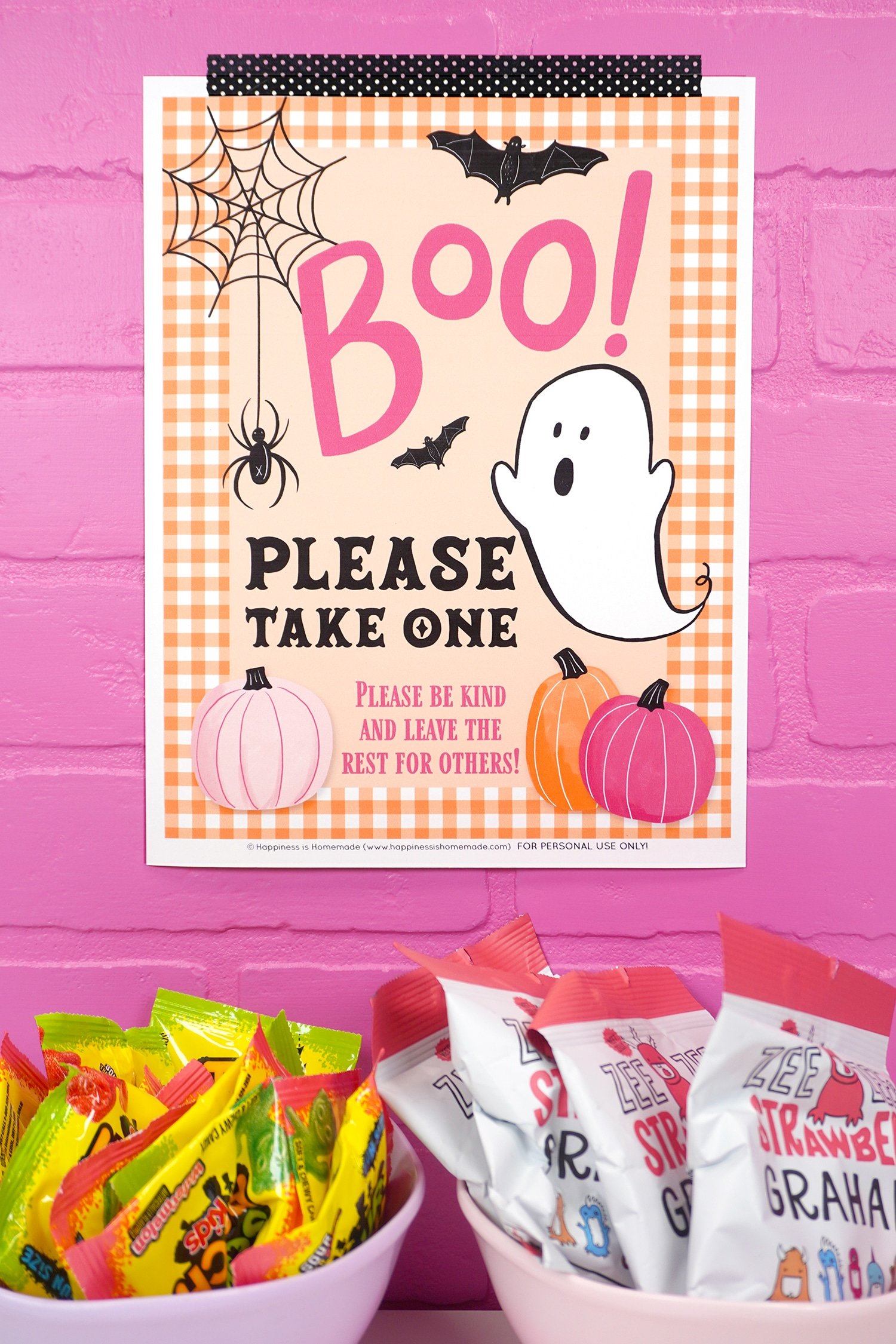 "Please Take One" Halloween sign with ghost and orange gingham border on pink brick background