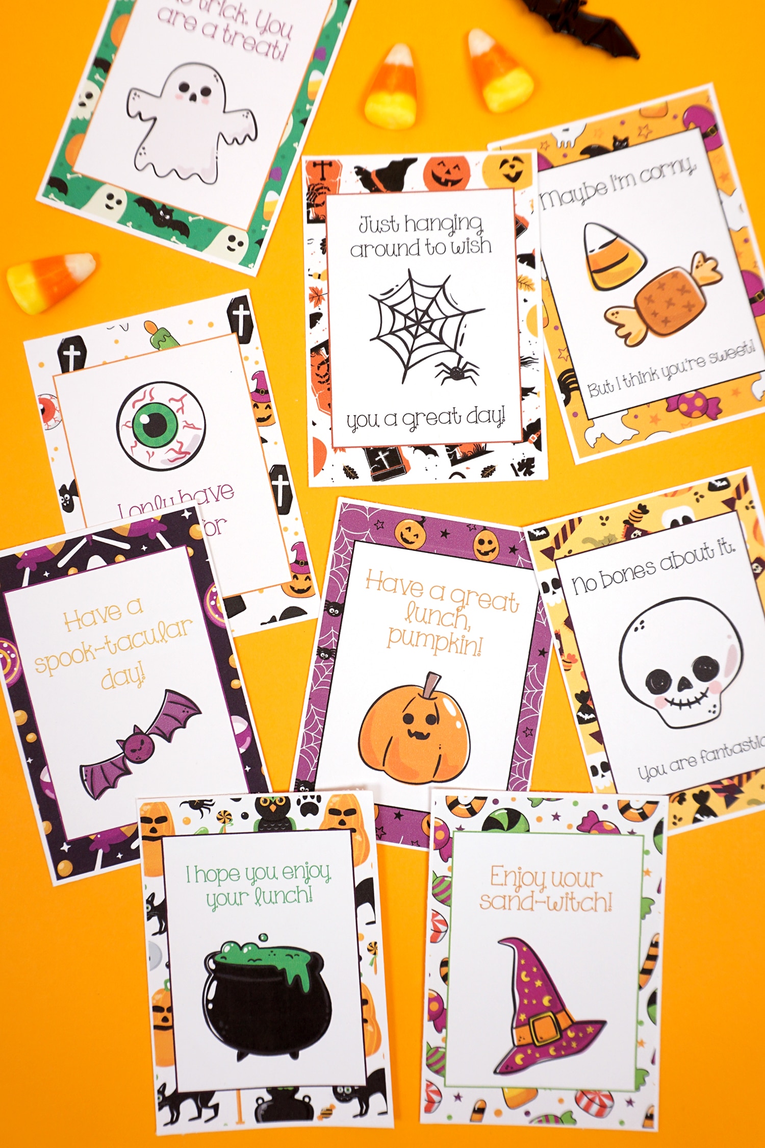 Halloween lunch notes scattered on an orange background with candy corn