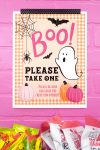 "Please Take One" Halloween Sign printable on a pink brick background with candy bowls