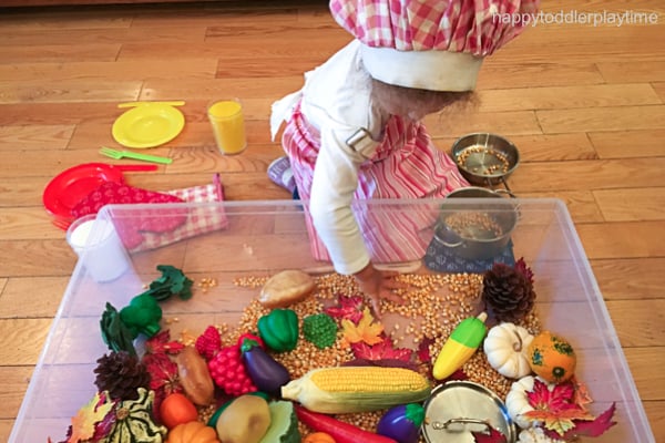 thanksgiving dinner sensory bin with small child playing