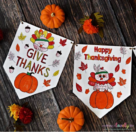 thanksgiving colored banner with fall leaf decor and mini pumpkins