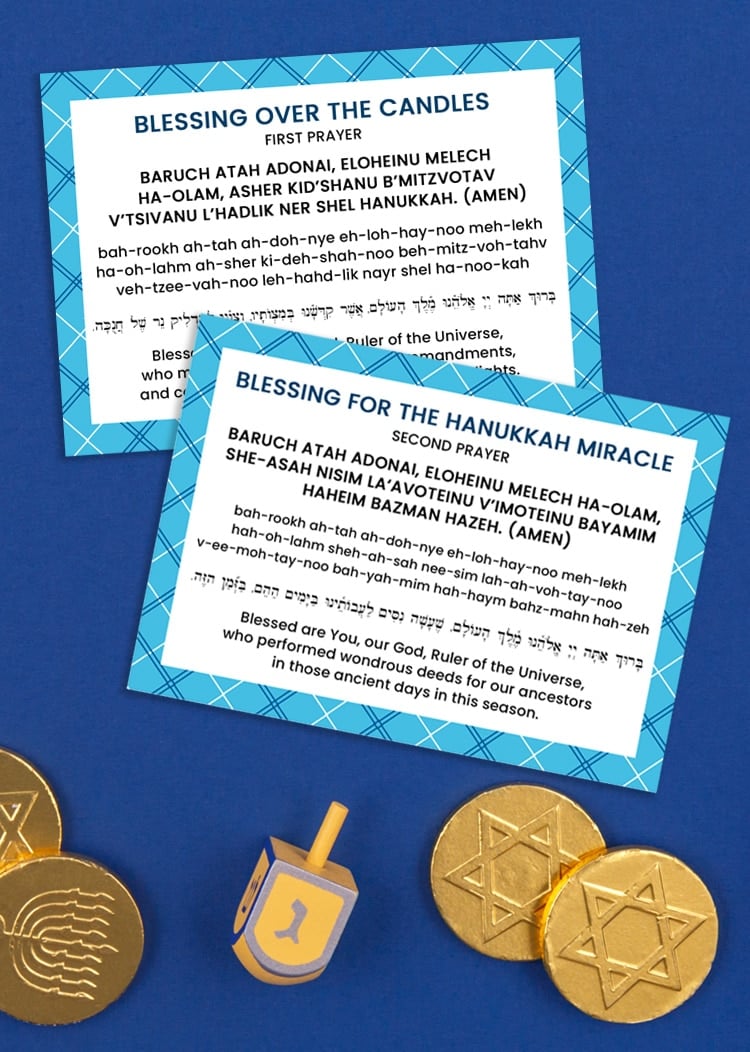 Dark blue background with Hanukkah blessing prayer cards, gelt, and a yellow dreidel 