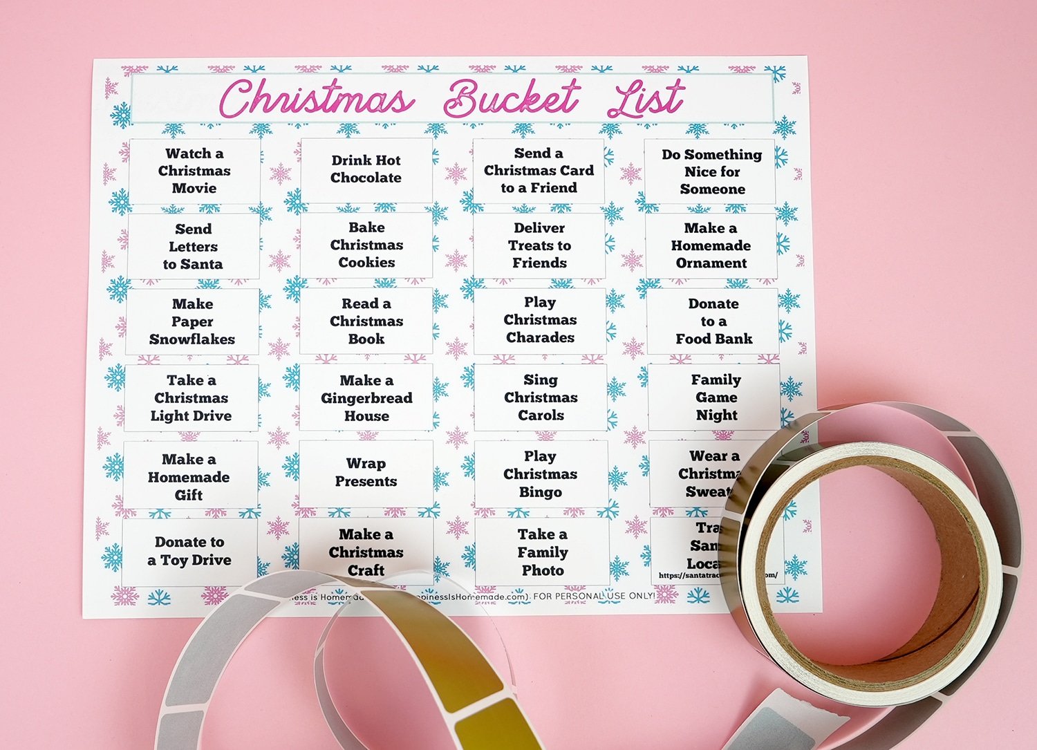 Christmas Bucket List printable on a pink background with roll of gold scratch-off labels
