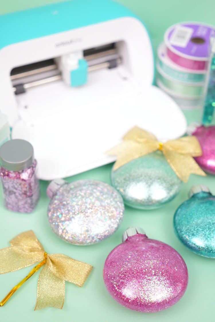Assorted glitter Christmas ornaments on mint green background