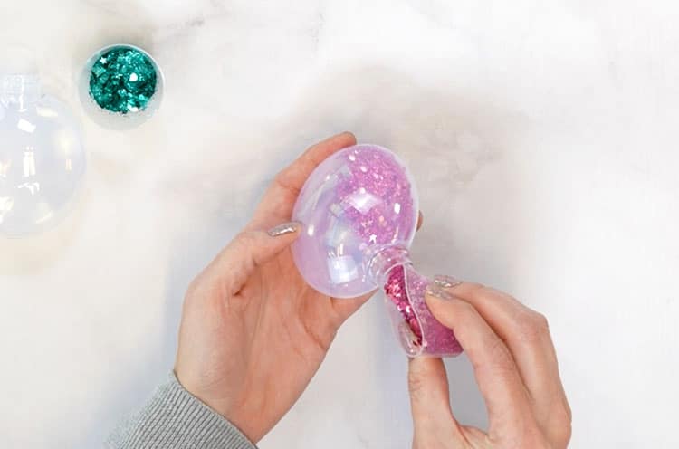 funneling glitter into plastic ornaments