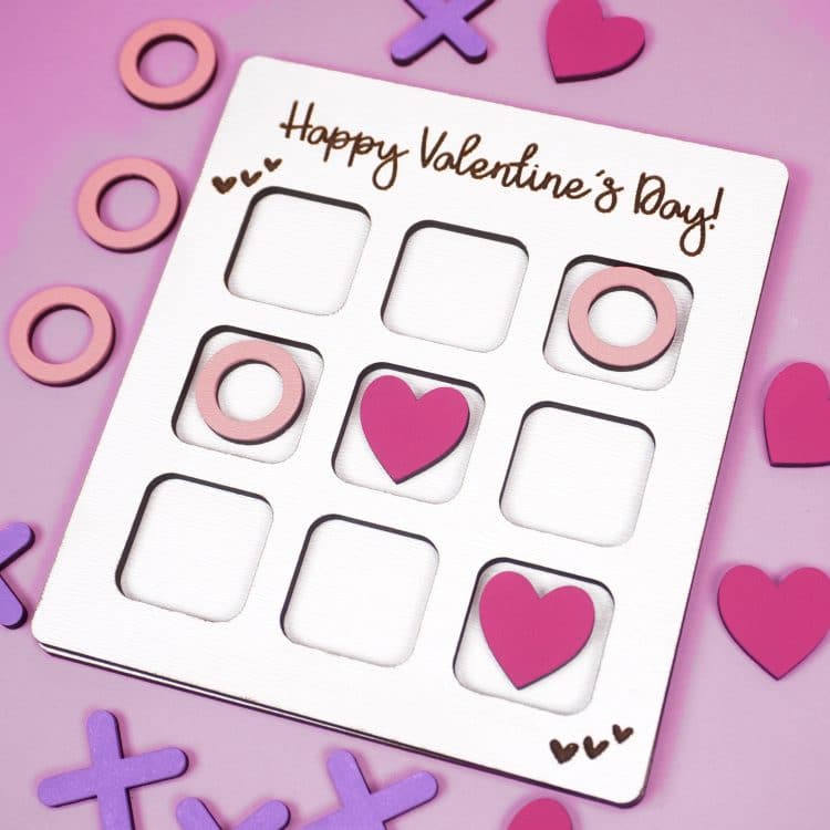 Valentine Tic Tac Toe game made with Glowforge laser SVG on a purple background with X's, O's, and pink hearts