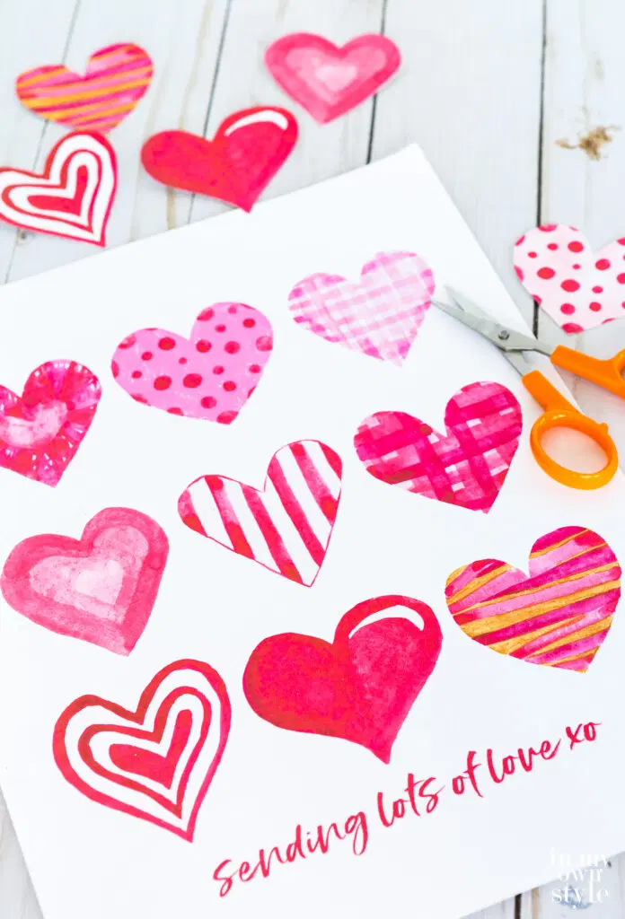 watercolor hearts on printed paper with scissors
