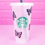 Close up of Starbucks tumbler cup with holographic butterflies on pink background