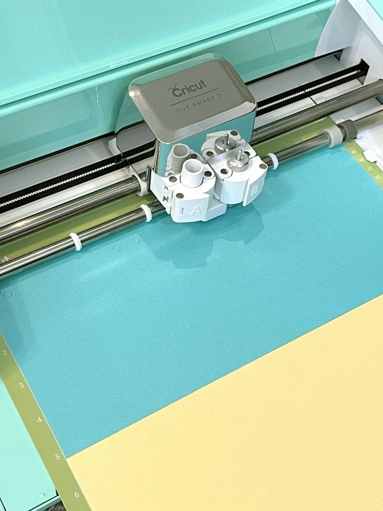 cricut machine cutting welcome banner on paper