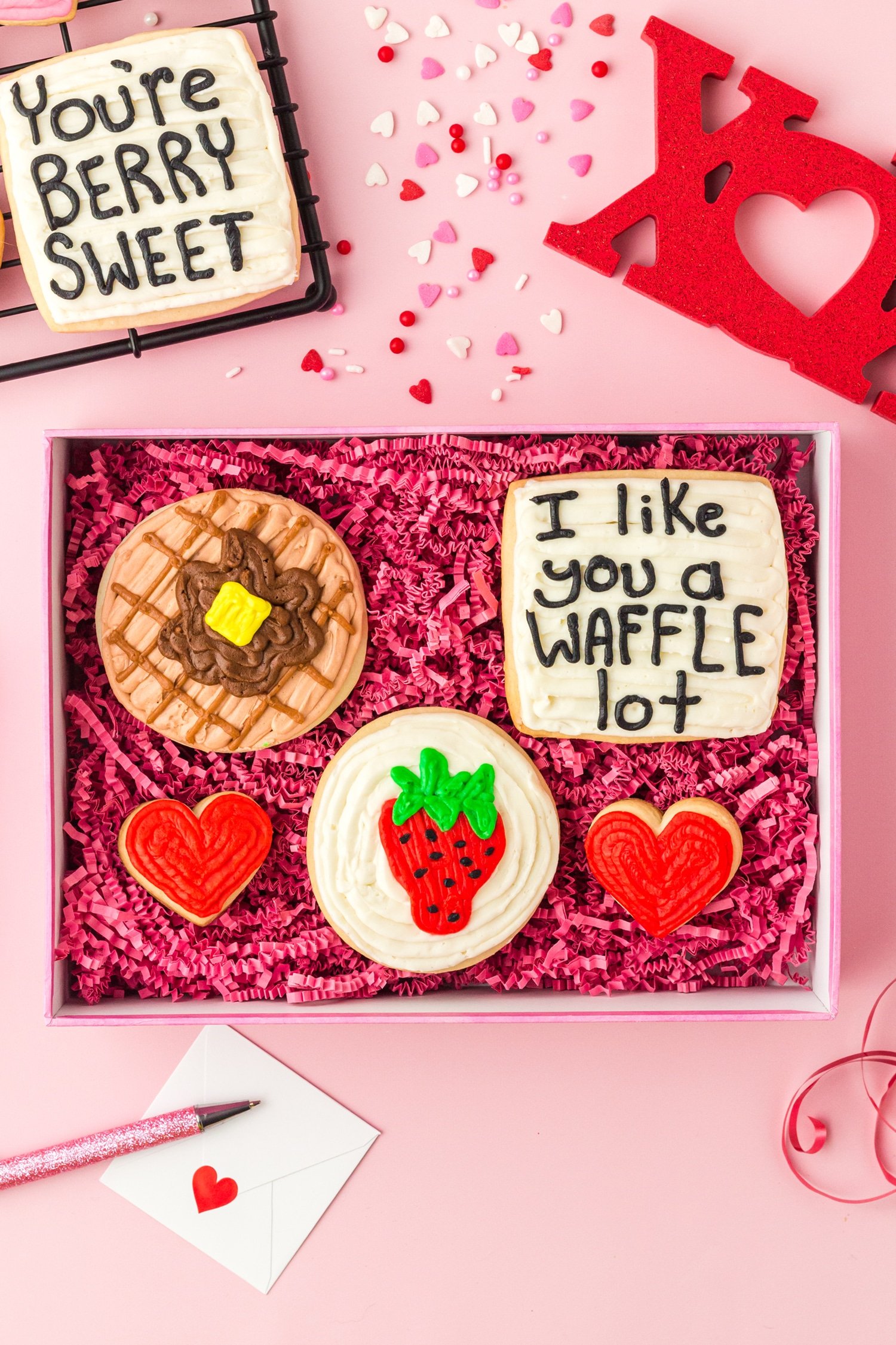 Set of adorable Valentine's Day sugar cookies in waffle and berry designs in a decorative pink box