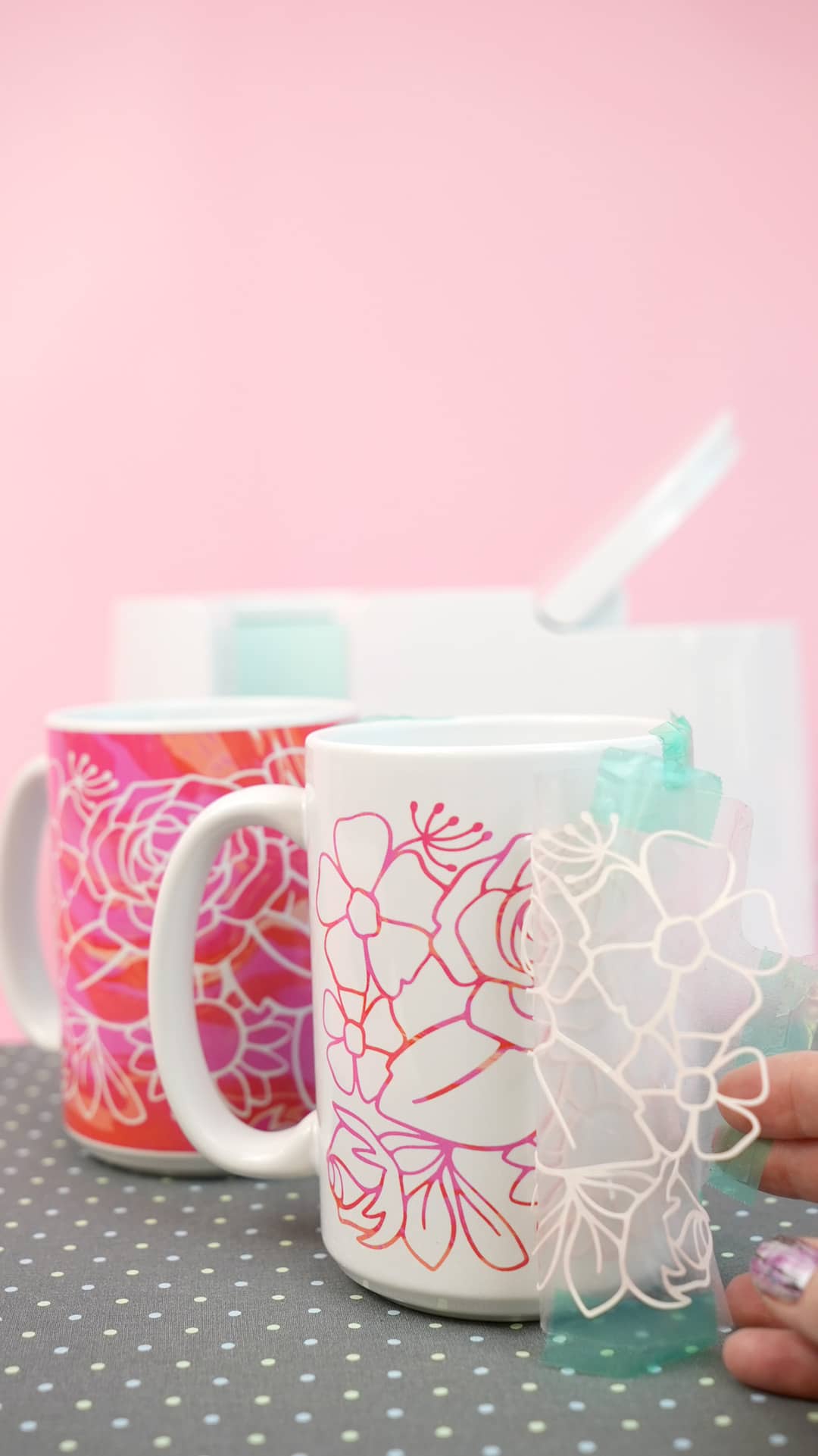 stencil being removed to reveal colored floral design on mug