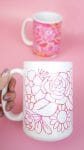 hand holding white mug with pink floral design