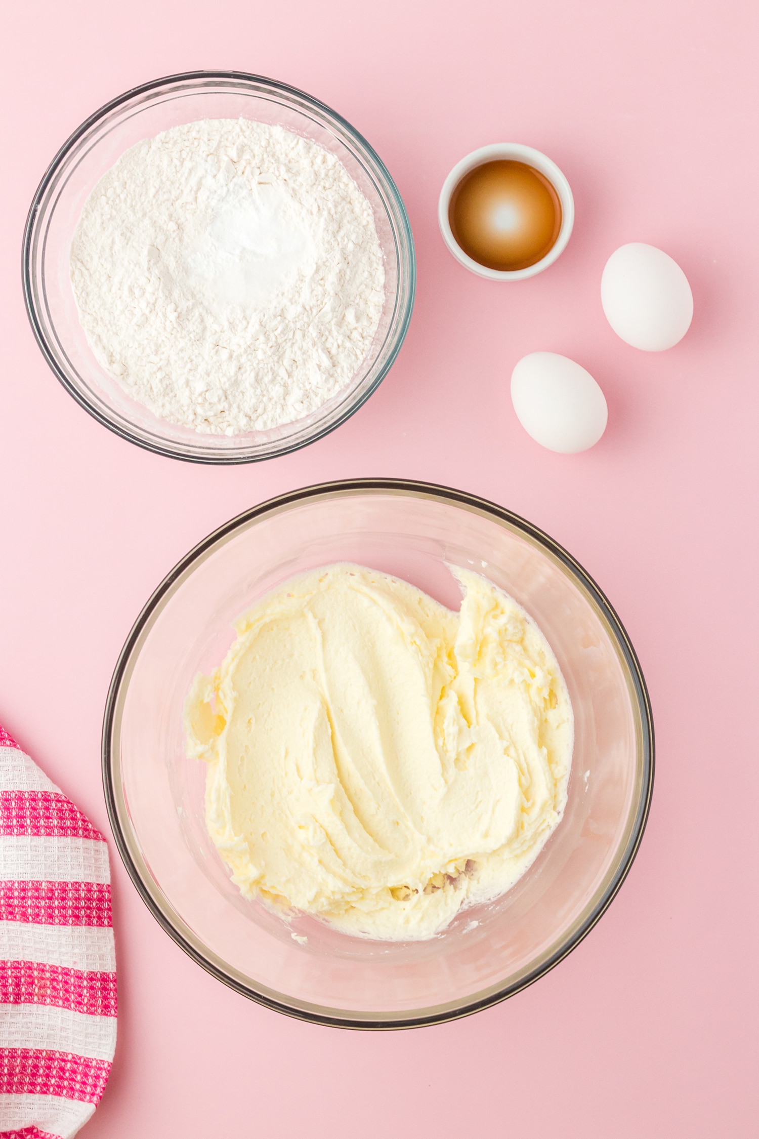 two mixing bowls with sugar cookie ingredients on pink background