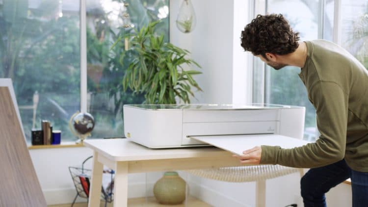 man loading glowforge with material