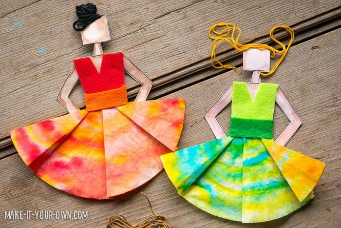 Red and green dyed coffee filters that make up the dress portion of a paper dancer craft.