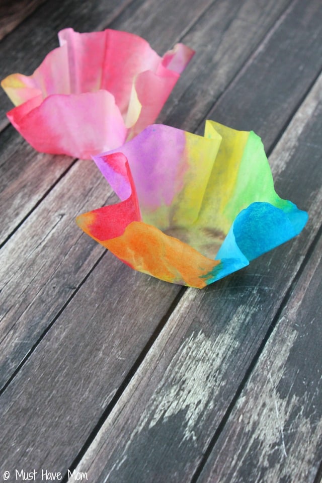 Rainbow dyed coffee filters folded into bowl shape.