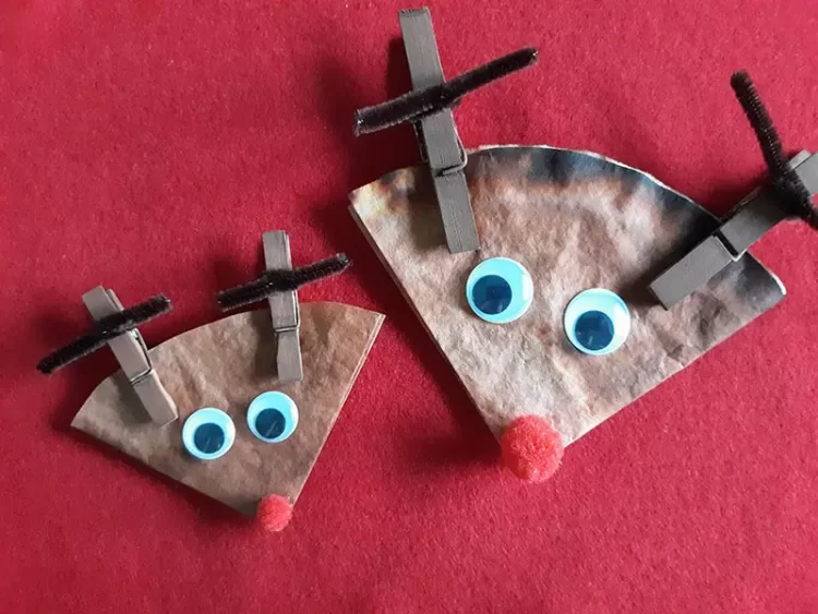 Brown coffee filters folded to look lie reindeer faces with brown clothespin antlers and red pom pom nose.