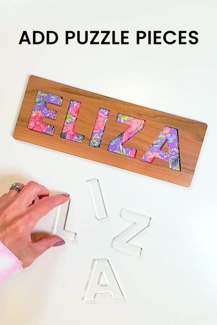 Hand adding clear acrylic letter puzzle pieces to a custom name puzzle