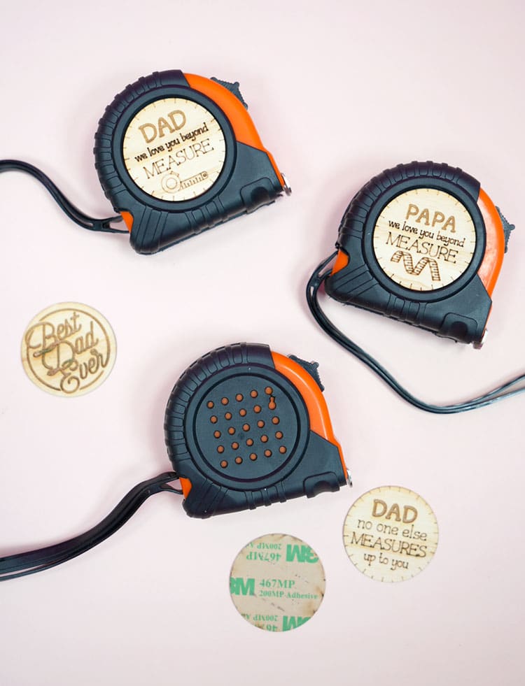 Tape measures and engraved wood stickers on light peach background