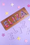 "Eliza" name puzzle on purple background with clear E-L-I-Z-A acrylic puzzle pieces