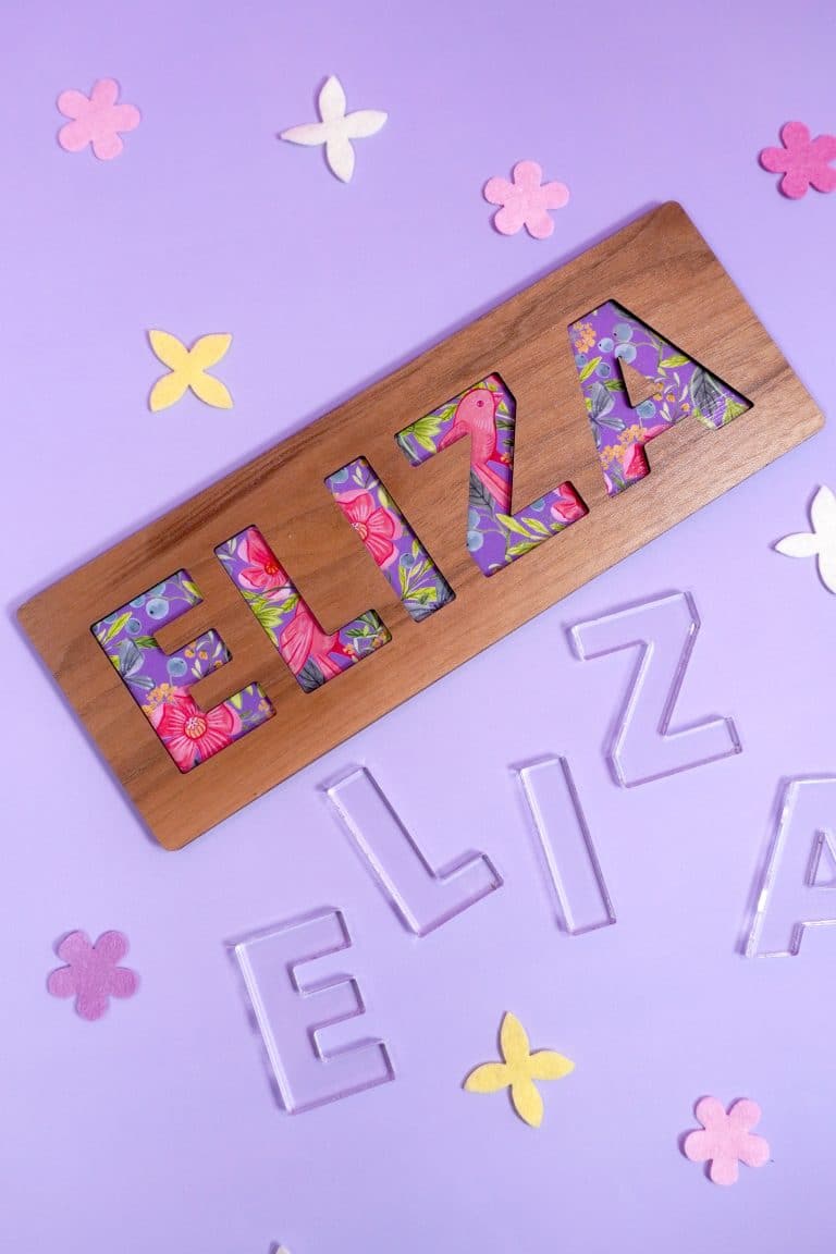 "Eliza" name puzzle on purple background with clear E-L-I-Z-A acrylic puzzle pieces