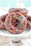 Close up of chocolate donuts with sprinkles on a cake stand