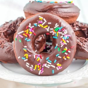 Close up of chocolate donuts with sprinkles on a cake stand