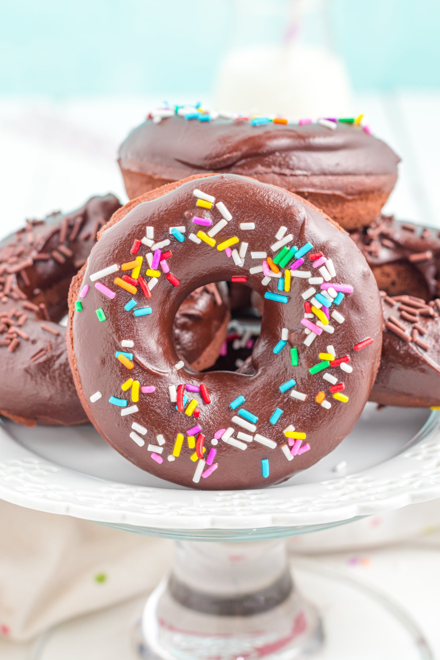 Close up of chocolate donuts with sprinkles on a cake stand