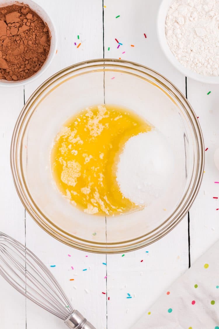 Melted butter and other ingredients in glass bowl on white background with sprinkles