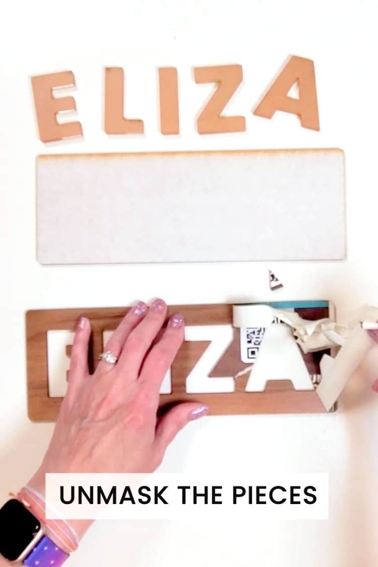 Hands unmasking laser cut pieces for a custom name puzzle
