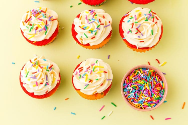 Colorful Rainbow Cupcakes on a yellow background