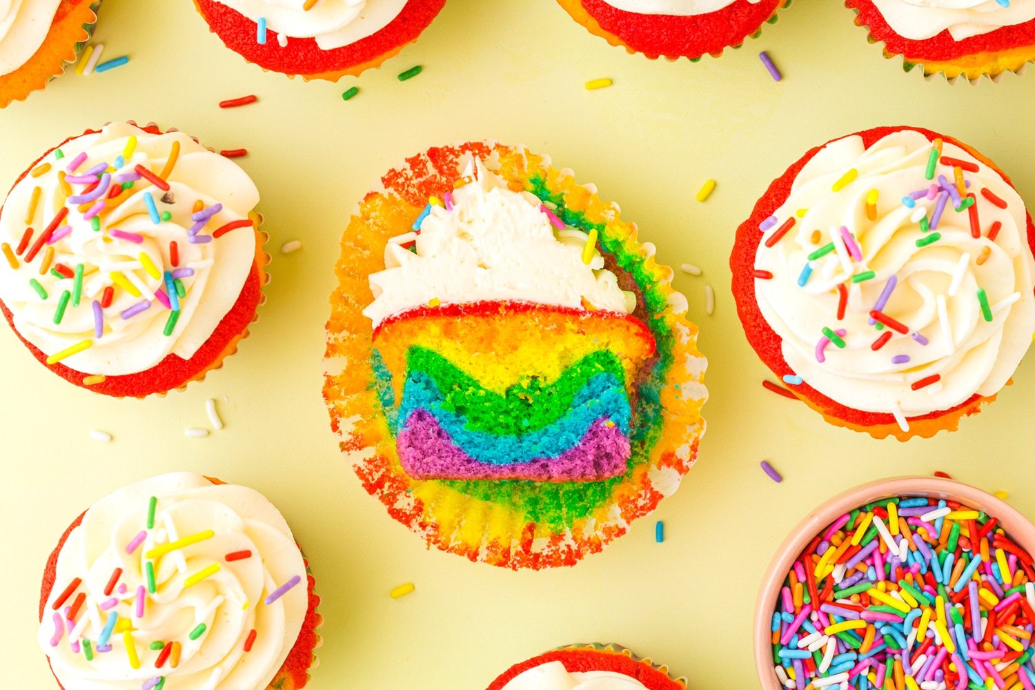 Rainbow Cupcakes with Vanilla Buttercream on a yellow background