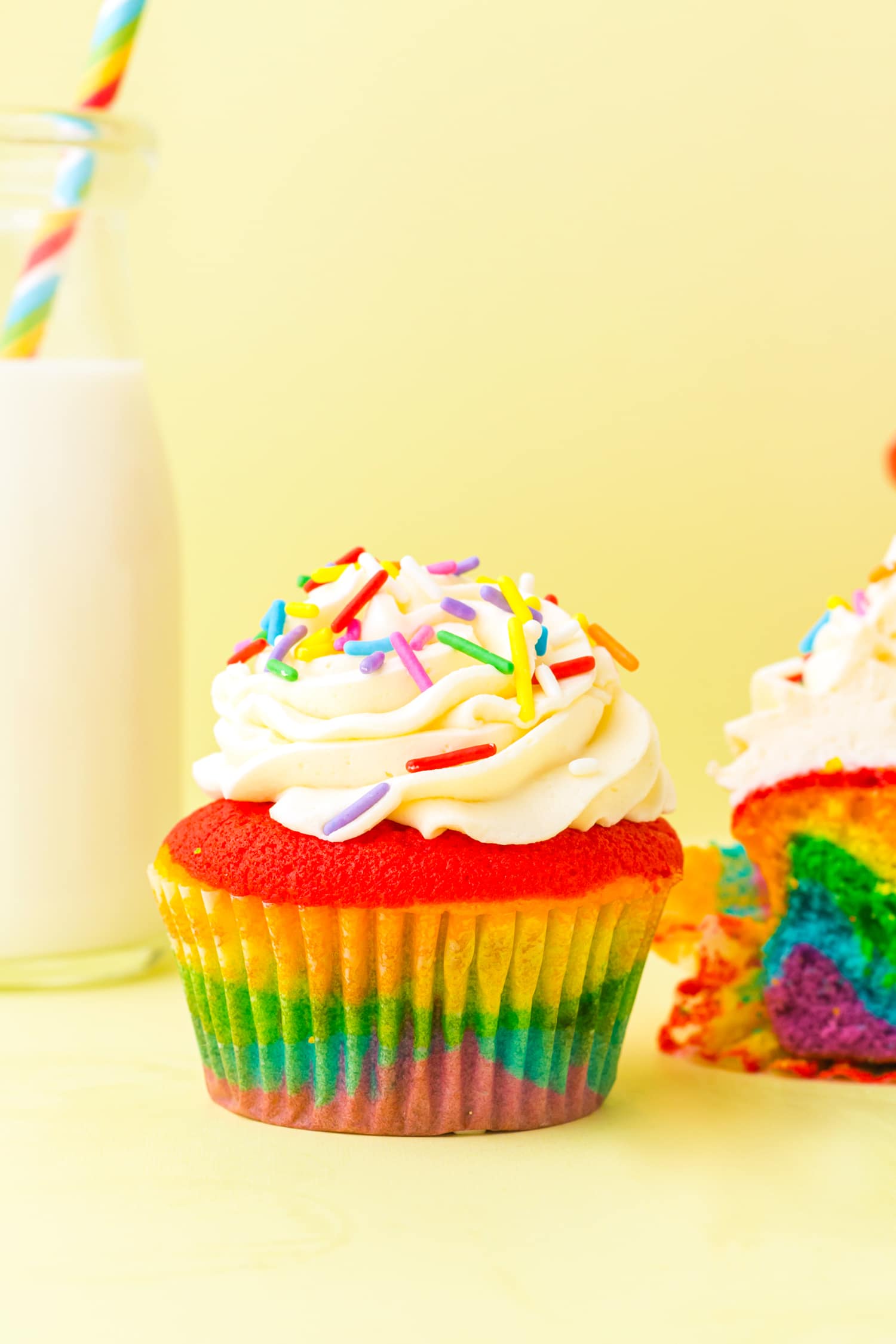 Rainbow Cupcake with sprinkles on a yellow background