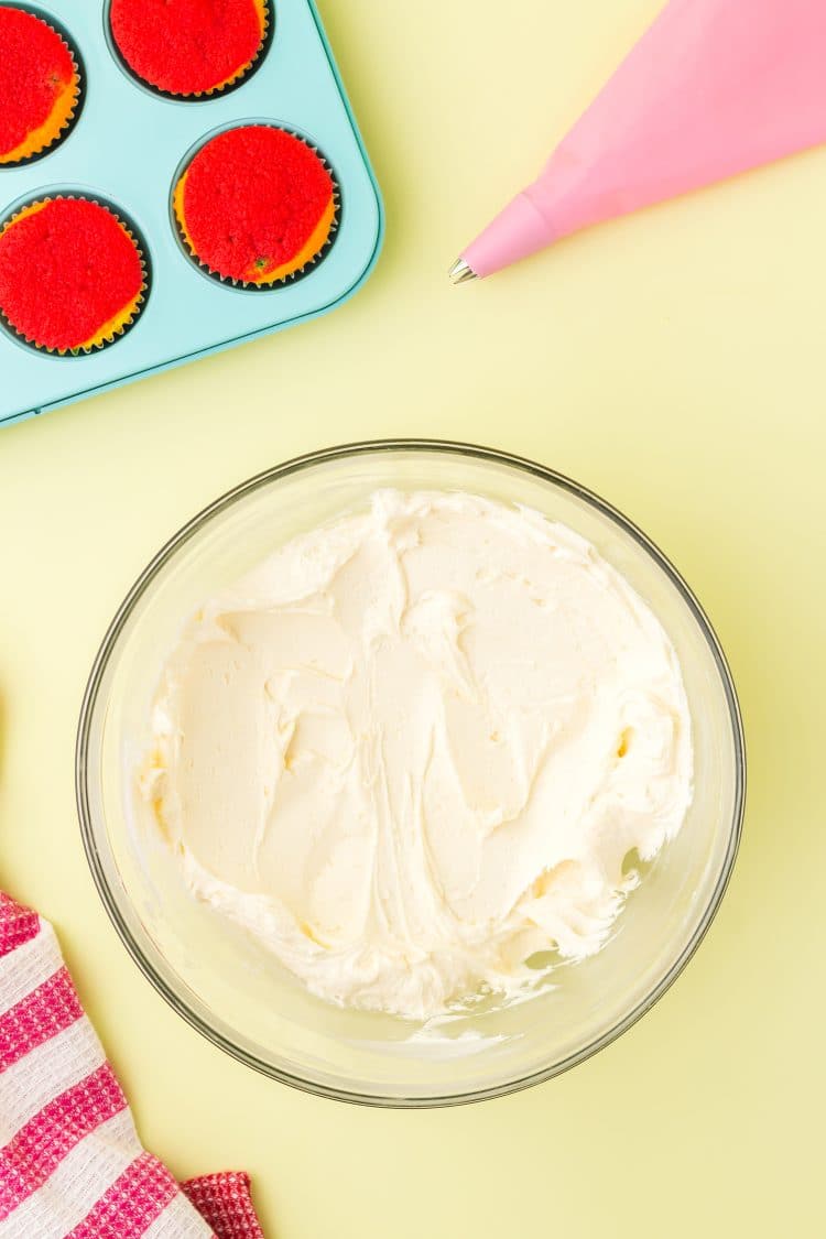 Vanilla Buttercream Frosting for Rainbow Cupcakes on yellow background