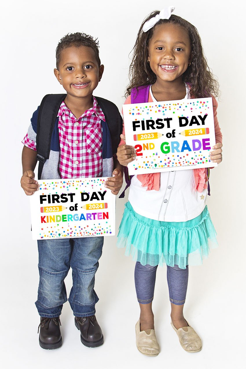 Two cute Black children dressed for school and holding printable First Day of School signs
