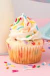 a cupcake with white frosting and sprinkles