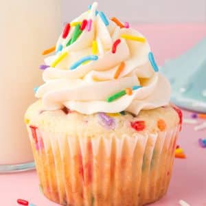 a cupcake with white frosting and sprinkles