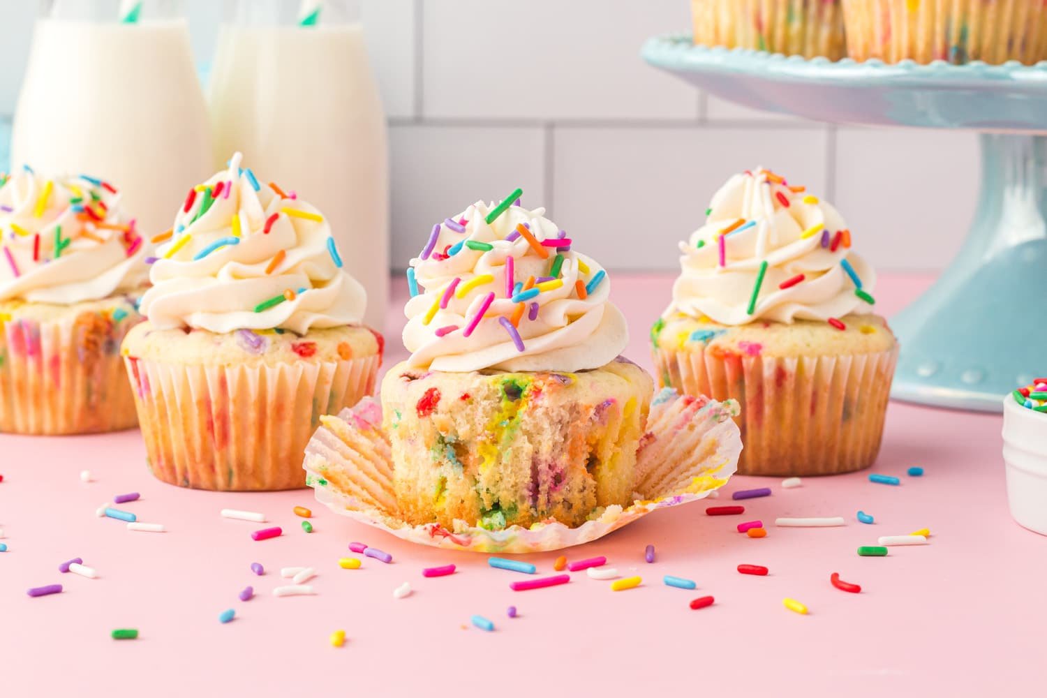 Unwrapping a Funfetti cupcakes recipe cake on pink background with sprinkles