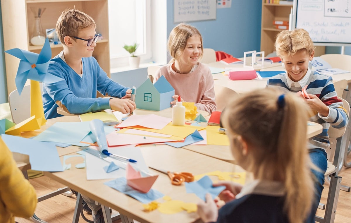 Elementary School Arts & Crafts Class Using Colorful Paper, Scissors and Glue to Create Fun Papier Mache.