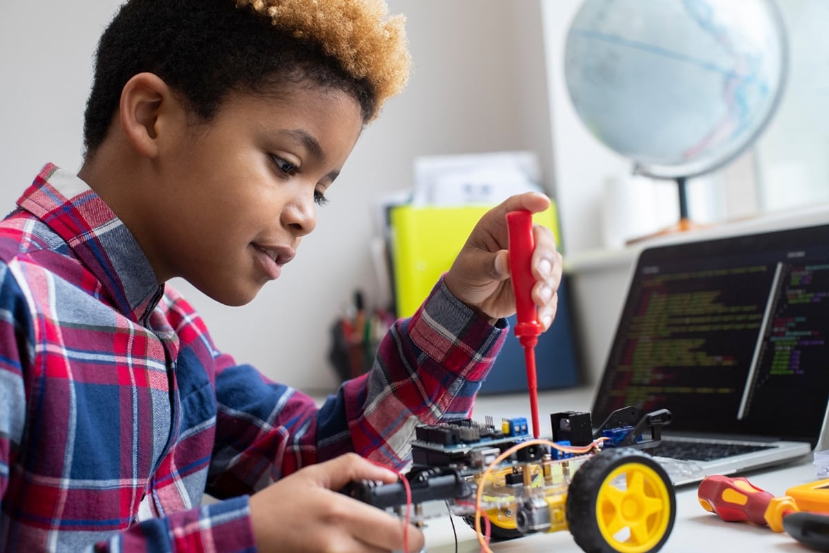 Black Male Elementary School Building Robot Car In Science Lesson