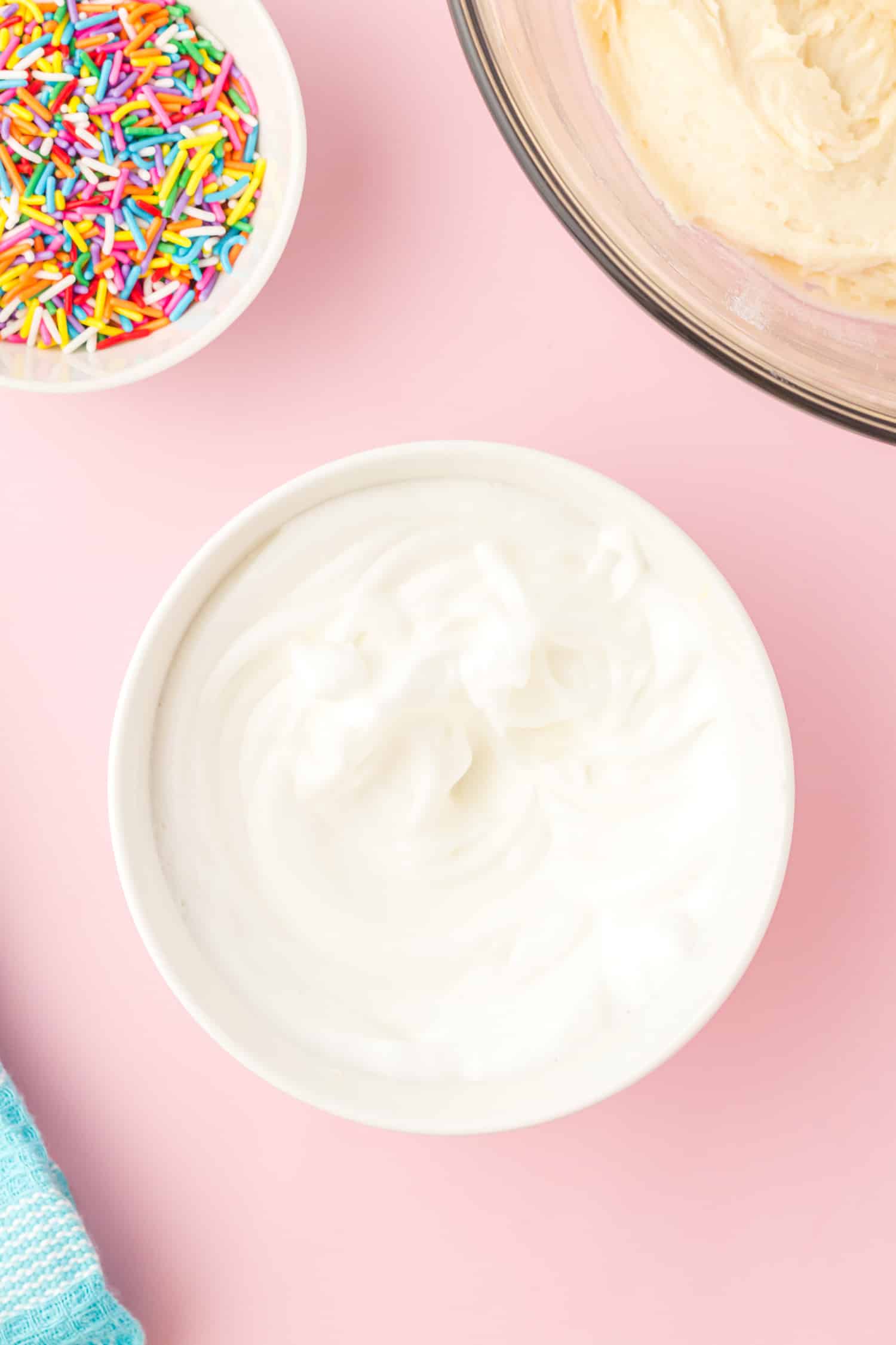 Whipped egg whites in bowl on pink background