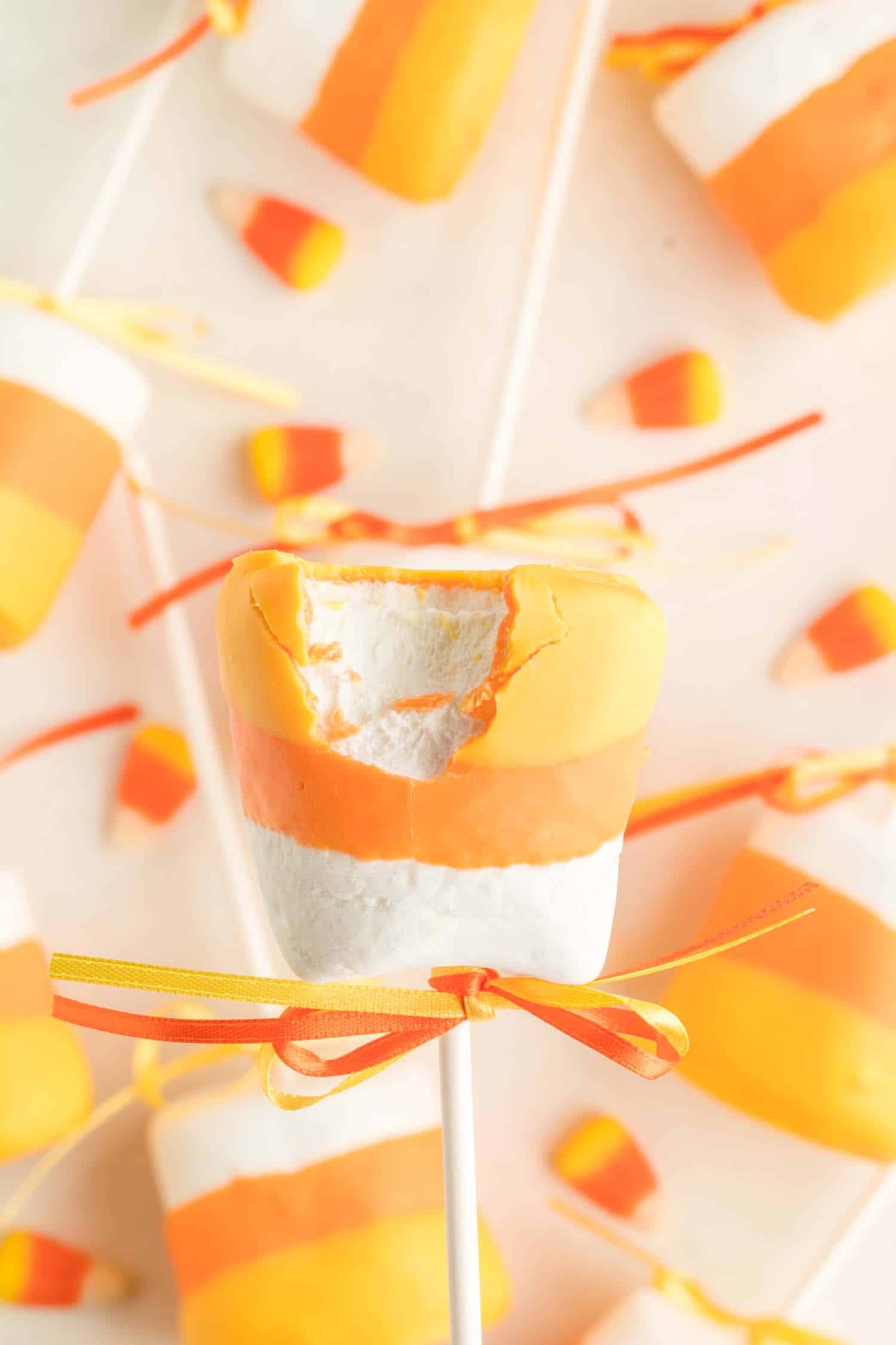 bitten candy corn marshmallow pops with candy corn background